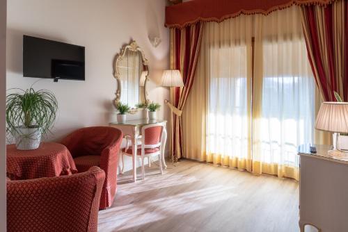 a living room with a table and chairs and a room at Hotel Canova Sport & Relax in Cavaso del Tomba