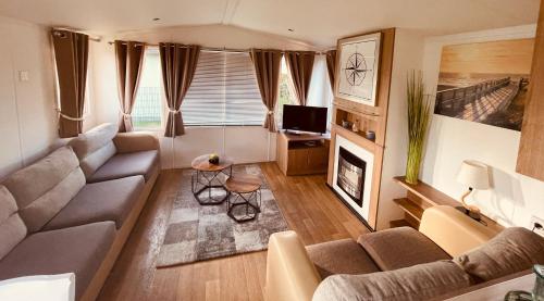 a living room with a couch and a fireplace at Ferienhaus Bordeaux Neuenpleen in Neuenpleen
