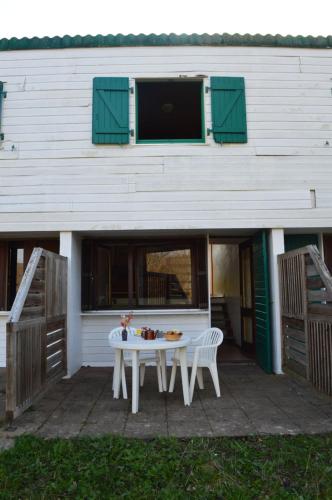 a white table and chairs in front of a building at Résidence Parc Les Cigognes Albé in Albé