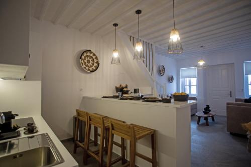 a kitchen with a counter and chairs in a room at Athena΄s Residency / Mykonos Town in Mikonos
