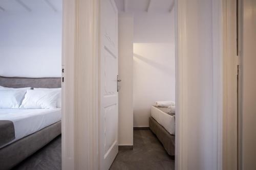 een witte slaapkamer met een bed en een bank bij Athena΄s Residency / Mykonos Town in Mykonos-stad