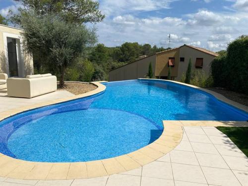 une grande piscine bleue dans une cour dans l'établissement Spacieuse villa avec piscine proche Pic Saint Loup, à Prades-le-Lez