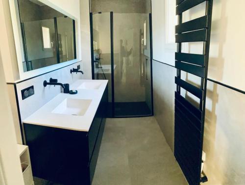 une salle de bain avec un lavabo blanc et une douche dans l'établissement Spacieuse villa avec piscine proche Pic Saint Loup, à Prades-le-Lez