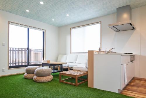 a living room with a couch and a table at 09 Resort Club -Green- in Azagawa