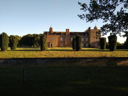 a large house with trees in front of it at The Walled Garden in Long Melford