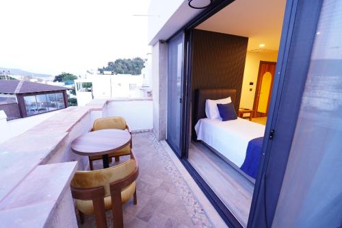 a balcony with a bed and a table and chairs at La Bonita Marina Hotel Bodrum in Bodrum City