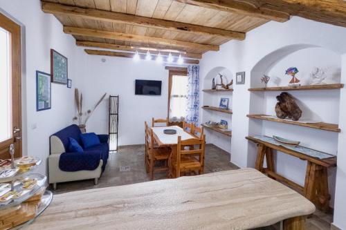uma sala de estar com uma mesa e um sofá azul em Apartment Conchiglie 2 em Cala Gonone