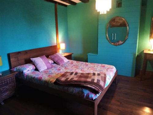 a bedroom with a bed with purple pillows and a mirror at Kukuma Etxea Habitaciones con derecho a cocina in Galarreta