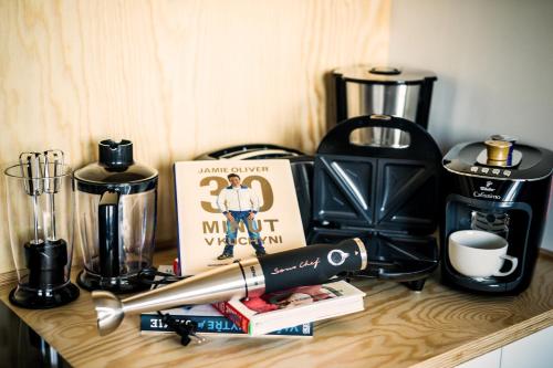 a counter with a coffee maker and a book and a pen at Residence Trafick in Prague