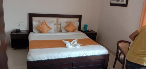a bedroom with a bed with a white flower on it at Hotel Tulsi in Rishīkesh