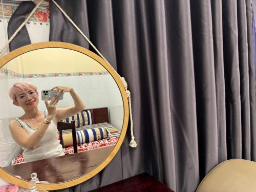 Eine Frau, die vor einem Spiegel fotografiert. in der Unterkunft NHÀ NGHỈ THANH XUÂN- Có cho thuê xe máy và xuất hóa đơn in Ấp Ðông An (1)