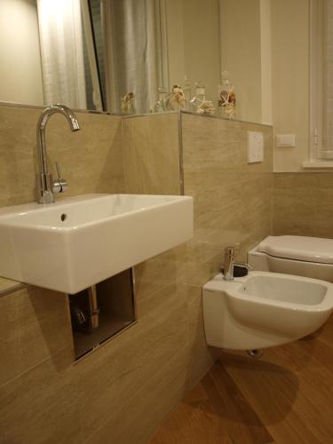 a bathroom with a sink and a toilet at Il Pontile Holidays Apartment in Marina di Pietrasanta