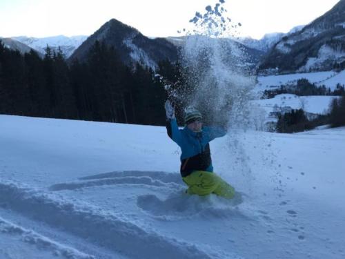 a person on a snowboard in the snow at Landhaus Tamberg zur Alleinnutzung in Hinterstoder