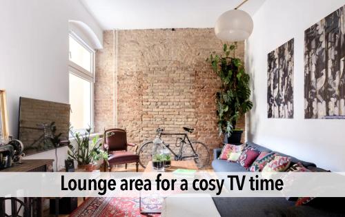 a living room with a couch and a brick wall at 90sqm Masterpiece-Loft in scenic Kreuzberg for up to 6 persons in Berlin