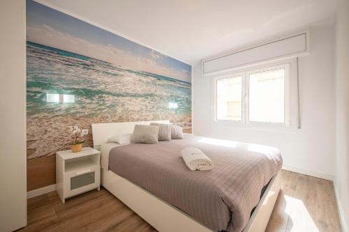 Schlafzimmer mit einem Bett mit Wandgemälde in der Unterkunft Apartamento a 100 metros de la playa in Pineda de Mar
