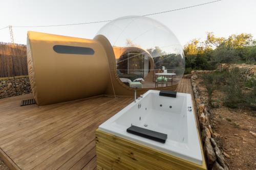 a glass dome house on a deck with a sink at Noches de Calig in San Jorge