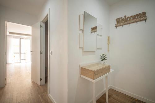 Habitación blanca con caja de madera en la pared en Apartamento a 100 metros de la playa, en Pineda de Mar