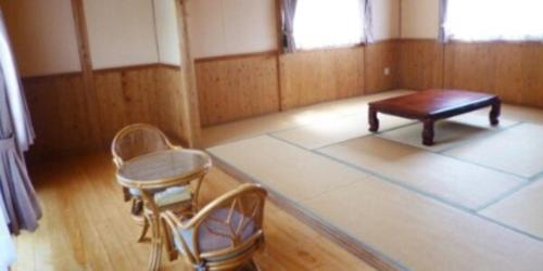 una habitación con una mesa y dos sillas. en 水辺プラザかもと, en Yamaga