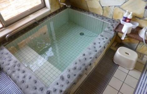 a bath tub in a bathroom with a toilet at 水辺プラザかもと in Yamaga