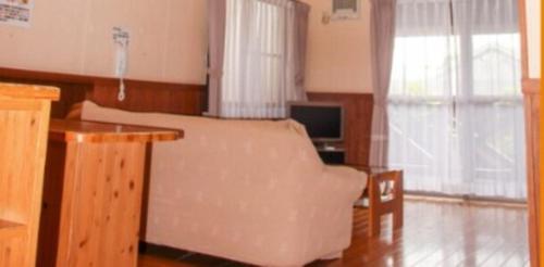 山鹿的住宿－水辺プラザかもと，客厅配有沙发和桌子