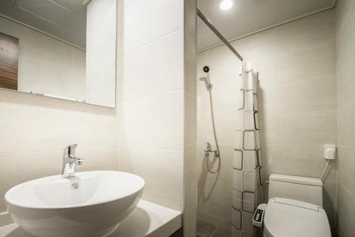 a bathroom with a sink and a toilet at W Ocean Pension in Seogwipo