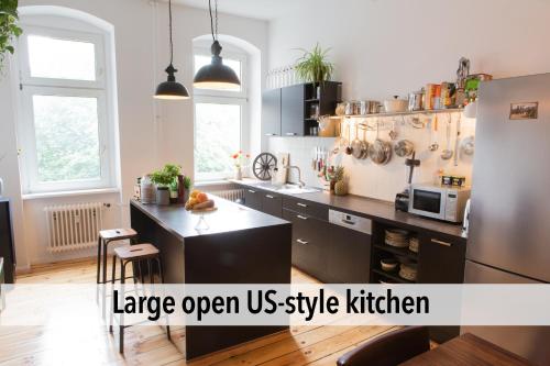 ベルリンにある90sqm Masterpiece-Loft in scenic Kreuzberg for up to 6 personsの大きなオープンスタイルのキッチンが備わります。