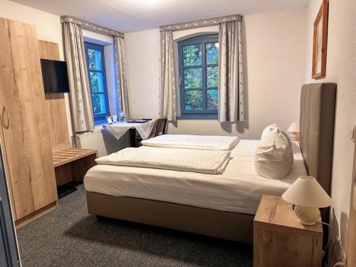 um quarto com uma cama e duas janelas em Schaumburger Ritter em Schaumburg
