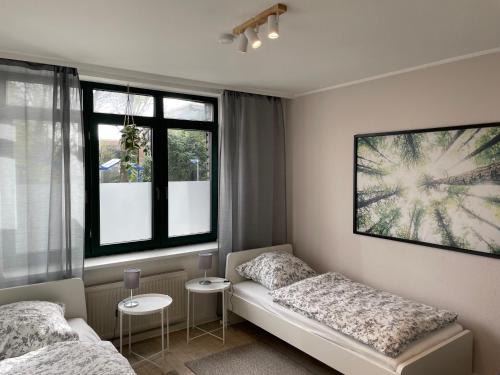 - une chambre avec 2 lits et 2 fenêtres dans l'établissement Ferien- und Messewohnung in Meerbusch, à Meerbusch