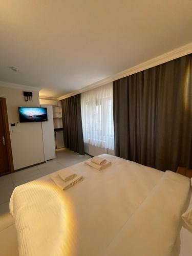 a hotel room with a large white bed and a flat screen tv at Green Star Pera Hotel in Istanbul