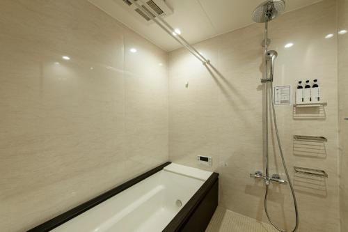 a bathroom with a bath tub and a shower at Kyohotel Kishotei Goshominami in Kyoto