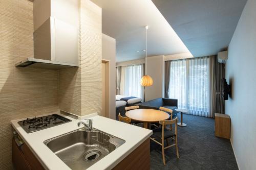 a kitchen with a sink and a table in a room at Kyohotel Kishotei Goshominami in Kyoto