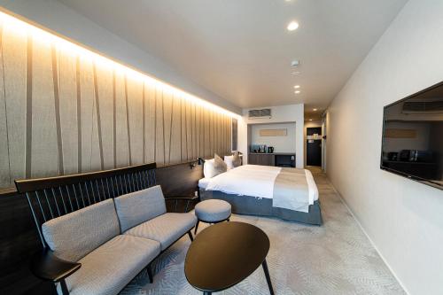 a hotel room with a bed and a couch at Kyohotel Kishotei Goshominami in Kyoto