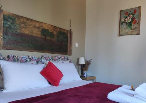 a bedroom with a white bed with red pillows at Spedion Kefallonia in Pesádha