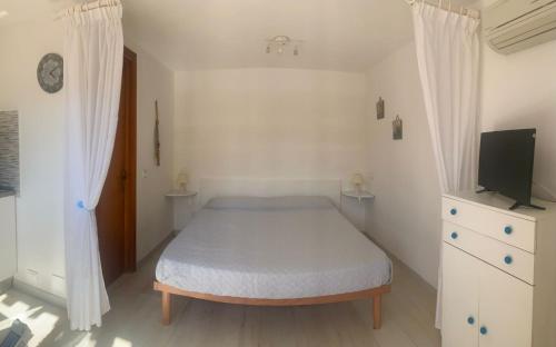 a small bedroom with a bed and a television at Monolocale “La Panoramica” in Rio Marina