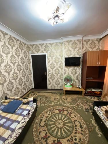 sala de estar con cama y alfombra en Исмаил Сомони 1, en Khujand