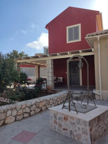 a house with a stone retaining wall and a patio at Spedion Kefallonia in Pesádha