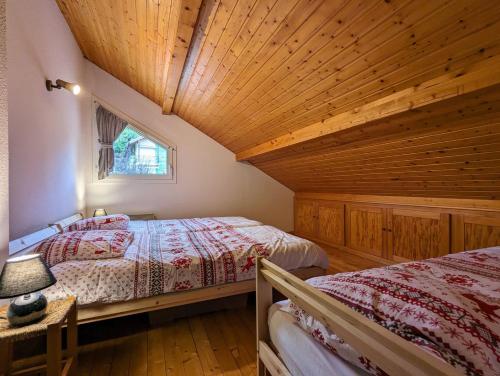 - une chambre avec deux lits et un plafond en bois dans l'établissement Duplex 5 personnes tout compris, à Gérardmer