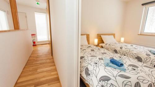 a bedroom with a bed and a mirror at Shirokin Chalet walking distance to Rusutsu Resort in Rusutsu