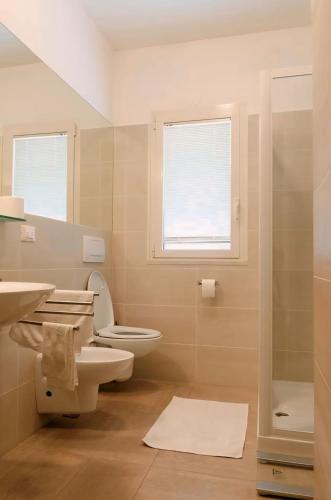 a bathroom with a toilet and a sink and a window at Luxury Suites Collection - Ponchielli 19 in Riccione