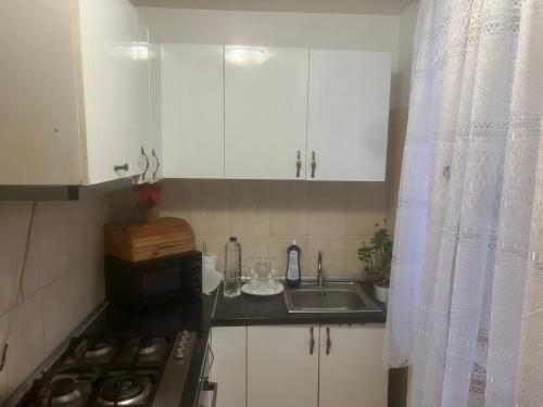 a small kitchen with white cabinets and a sink at Central Apartment ressidence city in Bucharest