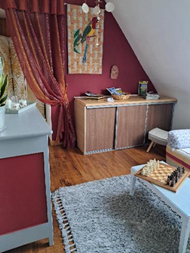 - un salon avec une table et un échiquier au sol dans l'établissement Aux Volets Bleus, à Sibiril