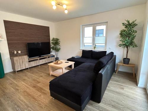 a living room with a couch and a flat screen tv at TOP-Ferienwohnung bei Berlin, bis 3 Gäste, Terrasse und Garten in Bestensee