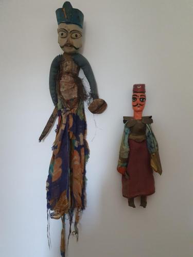 two puppets are hanging on a wall at la Bellavita rooms in Caltanissetta