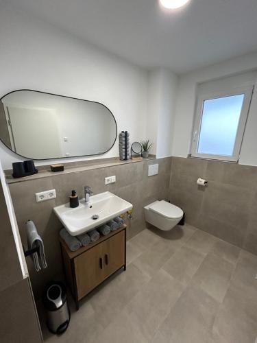 a bathroom with a sink and a toilet and a mirror at Jill Apartments in Rust