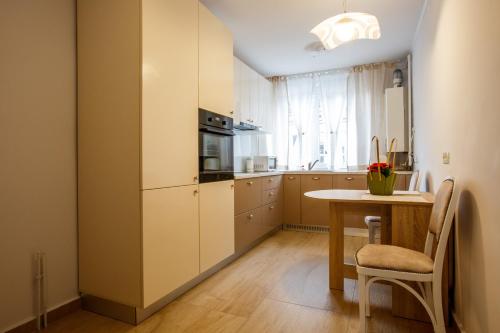 a kitchen with a table and a refrigerator and a table and chairs at Perfect Apartment Central in Braşov