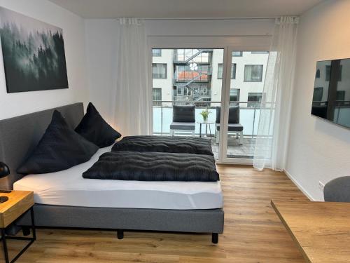 a bedroom with a bed and a balcony at Jill Apartments in Rust