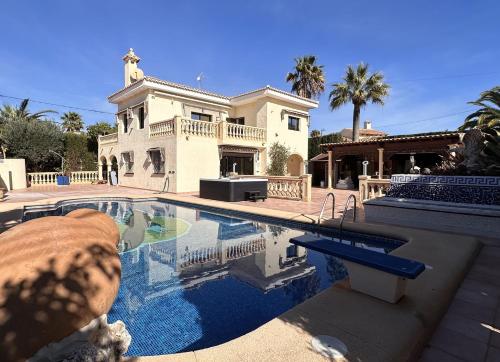 a large house with a swimming pool in front of it at Luxury Villa - pool, hot tub, aircon, TVs, home cinema, office, Gbit Internet, sports equipment, car in Calpe