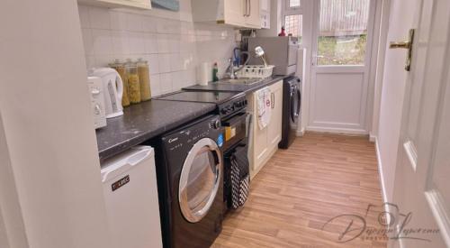a kitchen with a washer and dryer in it at VRY NICE PLACE London in London