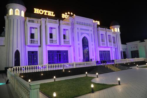 ein weißes Gebäude mit lila Lichtern drauf in der Unterkunft HOTEL SULTAN PALACE in Samarkand