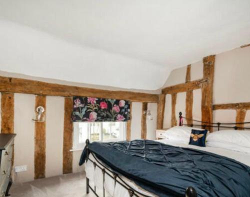 1 dormitorio con cama y ventana en Little Mouse Cottage, en Lavenham